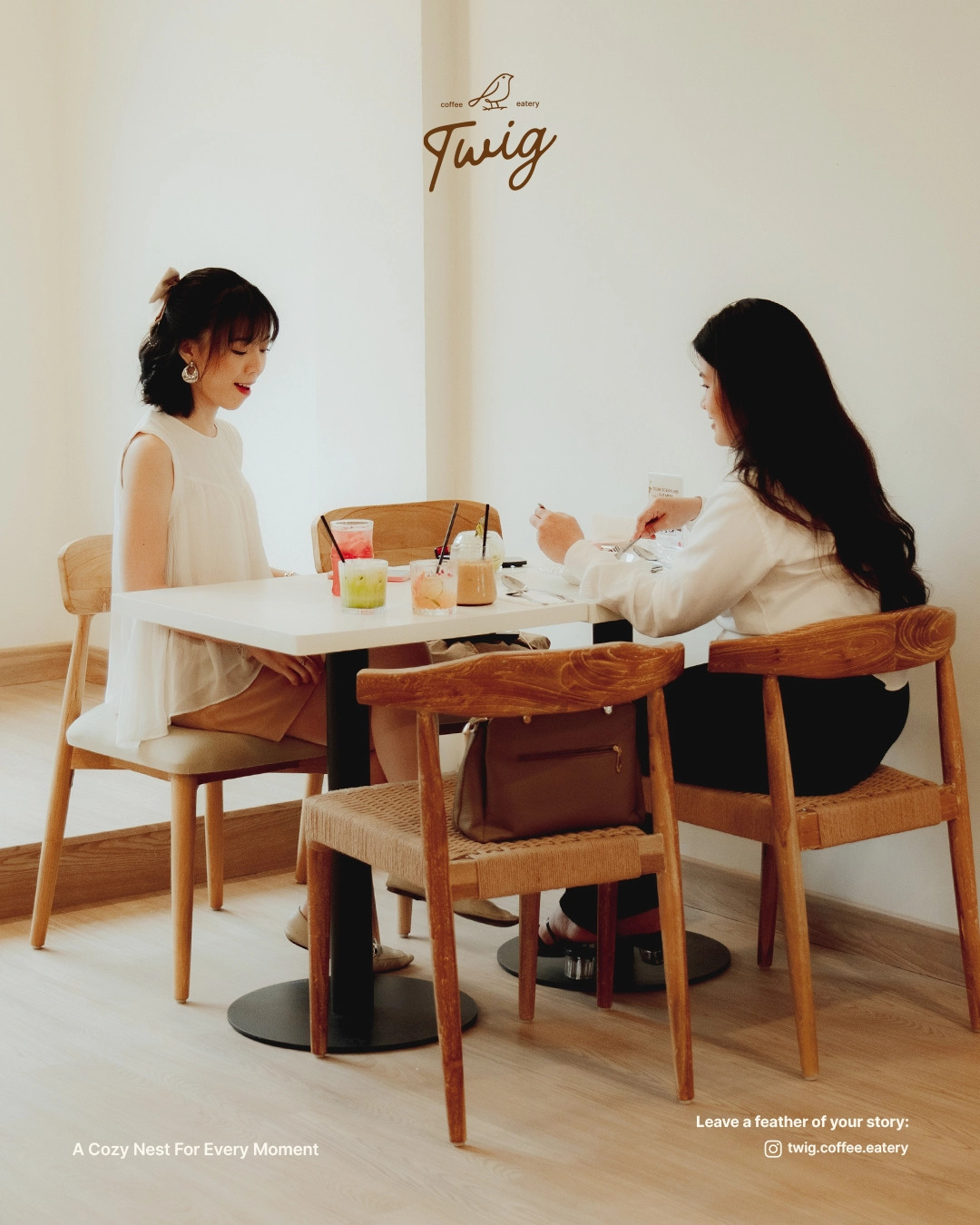 Two friends catching up over drinks at a table in Twig